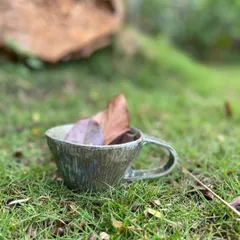 A stoneware mug with a rustic, textured finish, pictured here in the garden. I love creating pieces that feel connected to the earth they came from.