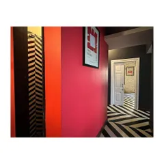 A hallway in the CoLive apartment, showing the use of vibrant color and pattern to manipulate a restrictive spatial matrix. This project is an exploration of creating generous social spaces within a load-bearing structure.