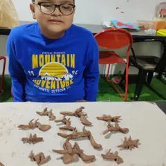 Happiness is getting to create an entire army of your favorite dinosaurs. This young paleontologist was completely in his element, sculpting each creature with incredible focus and imagination.