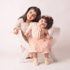 Two sisters, two beautiful smiles. Their matching outfits and playful poses make for an absolutely adorable sibling portrait.
