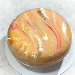 This custom-flavored entremet features a dark chocolate nutty crunch layer, almond jaconde, fresh orange jelly, and a rich chocolate mousse. The marbled mirror glaze makes it a stunning centerpiece.