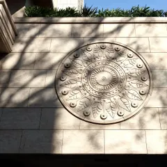 A close-up of a custom-carved stone medallion on the facade of our Pali Hill project. This intricate detail, capturing the play of sunlight and shadow, adds a touch of traditional artistry to the modern building.