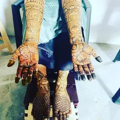 A full bridal set with matching traditional designs on both hands and feet, shown here after the henna has been applied.