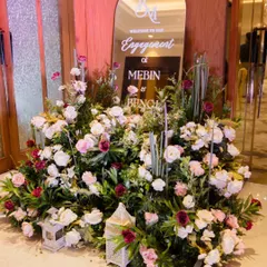 A beautiful floral entrance arrangement with a mirrored welcome sign for an engagement party. This creates a luxurious and welcoming first impression for guests.