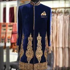 A truly royal statement. This is a deep blue velvet sherwani with magnificent gold zardozi embroidery, perfect for a groom who wants a grand and memorable wedding day outfit.