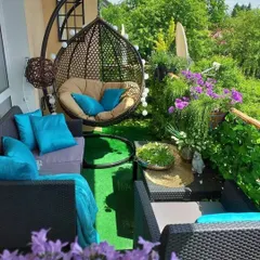 A duplicate of a vibrant and colorful balcony garden, perfect for showcasing how even a small space can be filled with life. The swing chair and plush cushions make it an inviting spot to relax.
