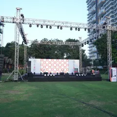 This wide shot of the 'Sound That Matters' outdoor concert shows the extensive trussing structure we erected. This rig is essential for flying the JBL line array speakers and Martin lighting fixtures at the correct height and angle for optimal audio and visual coverage over a large crowd area.