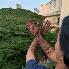 This design showcases intricate jaali work on the forearms, complemented by classic motifs on the palms for a balanced and elegant sangeet mehndi look.