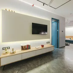 The entertainment unit is a sleek combination of rubberwood and a white wave board panel, providing stylish storage and a textured backdrop for the television.