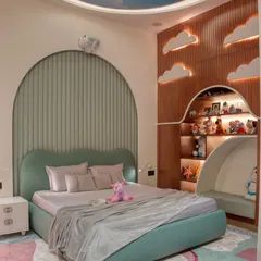 A whimsical kid's bedroom designed for dreams, featuring a custom cloud-shaped headboard, a ceiling painted like a blue sky, and backlit cloud cutouts on a wooden accent wall. The arched, fluted paneling adds another layer of soft texture.