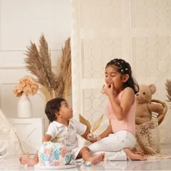 The sweetest moment of sharing! The older sister helps her baby brother with his smash cake.