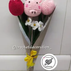 This adorable bouquet was customized to include a piggy stick nestled between crochet tulips and small white flowers. We love creating these playful and personalized arrangements.