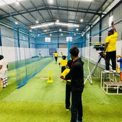 Inside the nets, our coaches use modern tools like video analysis to provide immediate feedback. Here, a coach records a session from an elevated position for a better technical review.