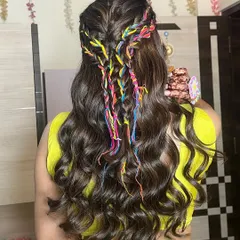 A look at the back of this creative Haldi hairstyle, featuring colorful threads braided into the hair for a playful and unique touch.
