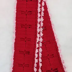 A flat-lay of the Aerith Scarf, showcasing the full length of the design and the contrasting ruffled border.