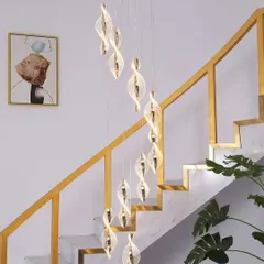 A spiral of modern pendants cascading down a staircase. This type of installation is one of our specialties, turning a simple stairwell into a dramatic feature.