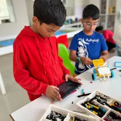 Precision is key in robotics competitions. A student carefully programs his robot using a tablet, preparing for the Indian Robotics Olympiad Techies category.