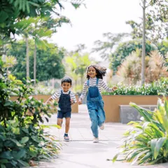 Siblings running hand-in-hand, full of energy and joy. My sessions are about letting kids be kids, and capturing their natural connection through play.