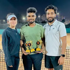 A winner's photo under the lights. Our tournaments often continue into the evening, showcasing the dedication of our players who compete with full energy, day or night.