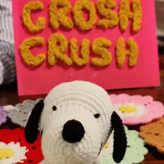My crochet Snoopy figure posing proudly in front of my "Croshcrush" sign at an exhibition.