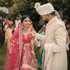 The groom leads his bride, a symbolic and beautiful moment in the wedding ceremony. The focus is on their connection amidst the crowd of loved ones.