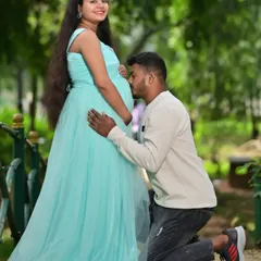 A beautiful moment between the expecting parents. The mother-to-be is wearing a simple yet elegant light blue tulle gown, perfect for a relaxed outdoor maternity shoot.