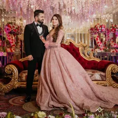 Here is a beautiful client couple celebrating their engagement. She is wearing my popular dusty rose ball gown, which features delicate feather-cuffed sleeves and a sparkling, full A-line skirt. This image captures the romantic, fairytale atmosphere I strive to create for your special moments.