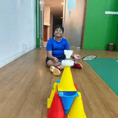Balancing a shuttle on a cone tower is a fun challenge that improves hand-eye coordination and focus. We mix these creative games into our sessions to keep things exciting.