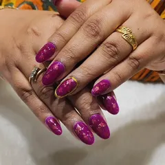 Luxury in a manicure. This set features a bold magenta chrome foil on almond-shaped nails, with one accent nail featuring a gold chrome outline. The foil gives a beautiful, textured metallic finish.