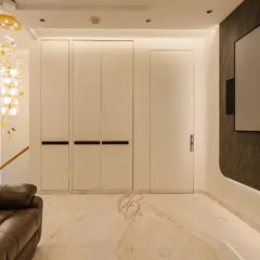 A view of the home theater with the hidden bar closed, showcasing the clean, minimalist design. The large projection screen is set against a dark stone accent wall with backlighting.