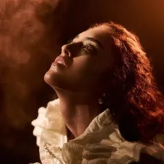 Capturing atmosphere is key. In this shot from the 'Velvet Shadows' series, I introduced smoke to catch the warm light, creating a soft, ethereal haze around the model and highlighting the texture of her ruffled collar.