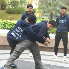 Defending against a knife is about controlling the weapon arm. This image shows a simultaneous block and counter, a core principle of Krav Maga. Your goal is to neutralize the threat and create an escape route.