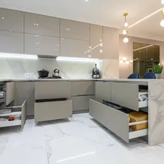A modern kitchen is the heart of the home, and we design them for both beauty and function. This space features a minimalist aesthetic with handle-less high-gloss cabinets, a marble-finish countertop, and smart, soft-close drawers that reveal maximum storage, ensuring a clutter-free and premium cooking experience.