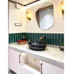Another view of the passage vanity, highlighting the emerald green tile backsplash and the unique, natural form of the stone basin.