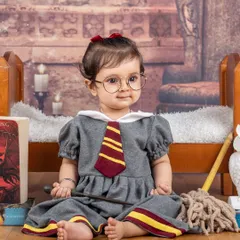 A sweet and serious little witch, holding her glasses and wand. The details in her dress and the backdrop make this Harry Potter portrait so special.