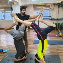 Trust and connection are at the heart of our practice. Here, we guide students through a partner headstand, a posture that builds not only physical strength but also deepens the bond between practitioners.