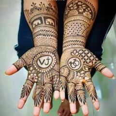A clear view of the "VJ" initial mehandi, showcasing the bold, clean lines of the letters and the surrounding detailed patterns.
