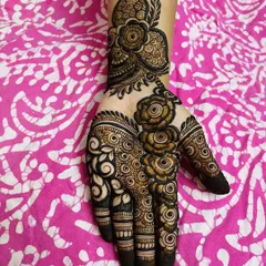 This party-style mehendi features a bold floral vine that trails down the hand. The combination of thick and thin lines gives it depth and makes it incredibly eye-catching.