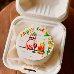 A fun and colorful birthday cake for a sister, featuring a cool cat with sunglasses, a glass of wine, and fries. The multi-colored "happy bday sis" text adds to the playful vibe.