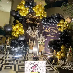 Here’s a look at a chic and modern 40th birthday celebration we designed. The decor features a bold black and gold balloon arch, a custom backdrop, and elegant pampas grass arrangements for a sophisticated party vibe.