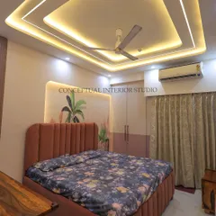 This bedroom showcases a modern look with a beautiful false ceiling design with cove lighting, creating a warm and inviting ambiance. The bed has a plush, fluted headboard.