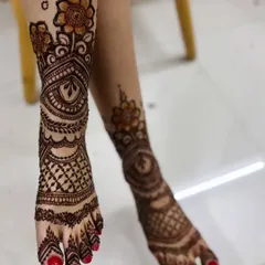 A full and intricate design covering the entire foot and ankle. This style combines floral elements with dense, traditional patterns, perfect for a bride who wants heavy mehendi on her feet.