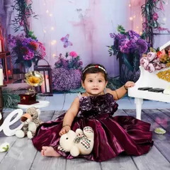 For this first birthday shoot, we chose a rich, purple-toned theme. The miniature grand piano adds a touch of sophistication and fun, perfectly complementing the baby's beautiful formal dress.
