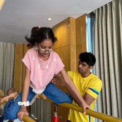 A young gymnast gets some pointers from our coach on the parallel bars. We tailor our instruction to each child's skill level, from beginner to advanced.
