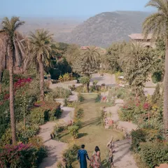 A couple walks hand-in-hand through the lush, terraced gardens of Fort Tijara, with the Aravalli hills providing a serene and picturesque backdrop for their love story.