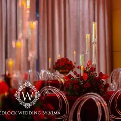 A luxurious centerpiece featuring a bouquet of deep red roses in a golden vase. This classic and elegant detail was part of a glamorous red-themed reception.