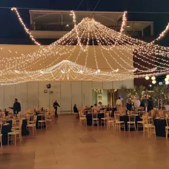 A stunning canopy of draped fairy lights creates a spectacular ceiling for this outdoor reception. This lighting design is one of our signature services for transforming large open spaces.