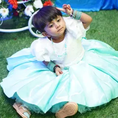A candid photo of a little girl in a beautiful party dress at her birthday celebration. I love capturing these unposed, natural moments that truly show a child's personality.
