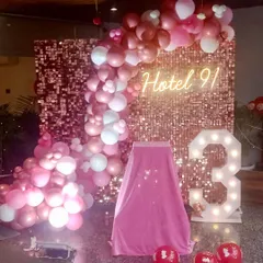 We celebrated Hotel 91's third anniversary with this elegant rose gold setup. The decor included a sequin wall, a custom neon sign for the hotel, a large marquee number '3', and a matching balloon arch.