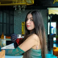 A sophisticated portrait at a bar. The model holds a drink, adding to the chic, evening-out atmosphere of the shoot. The lighting and setting are perfect for capturing a glamorous look.